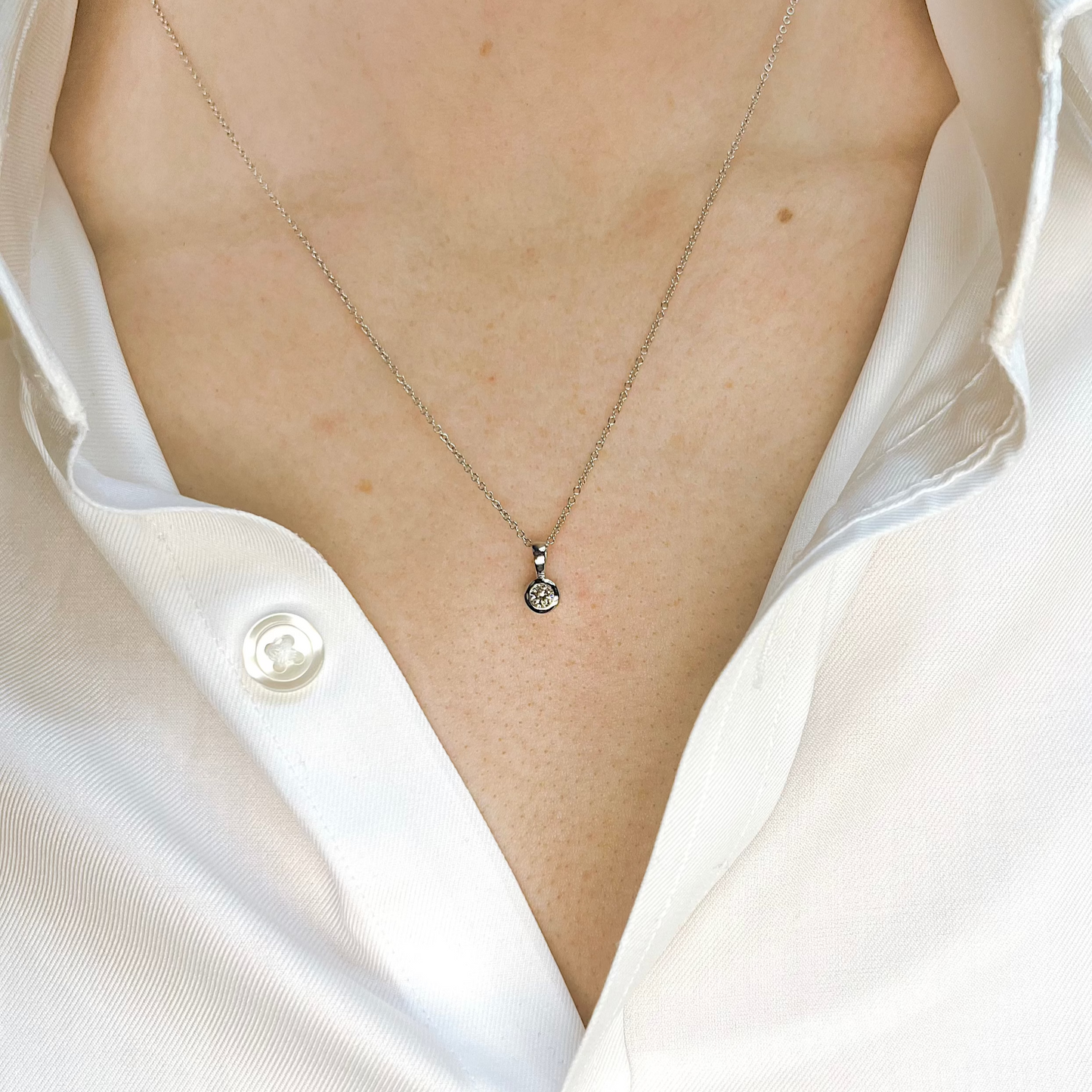 Diamantanhänger aus Weißgold mit Solitärdiamant in Zargenfassung an Halskette getragen