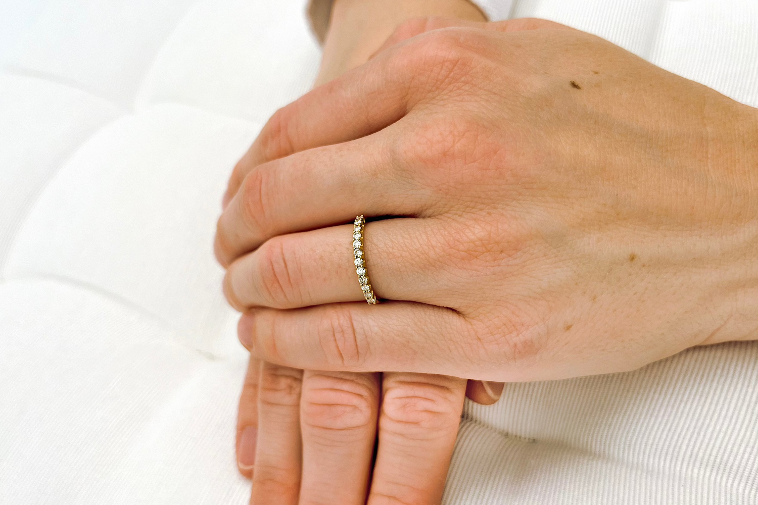 Ein Vorsteckring aus Gelbgold mit 0,25ct Diamanten an der Hand einer Frau