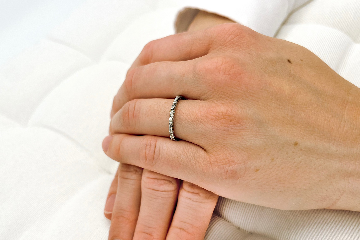 Ein Weißgold Memoryring mit einem halben Karat Diamanten an einer Frauenhand getragen