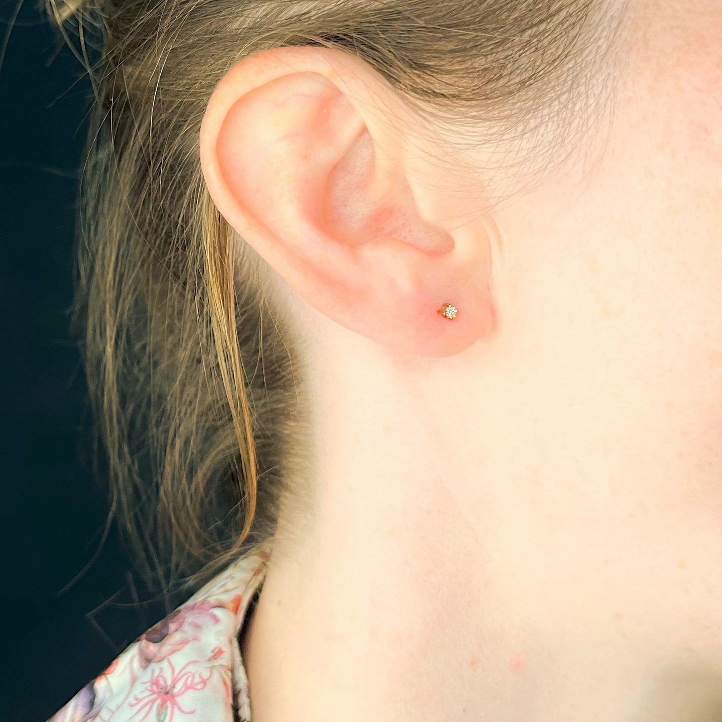 Kleine Diamantohrstecker aus Rotgold mit Solitärdiamant getragen am Ohr