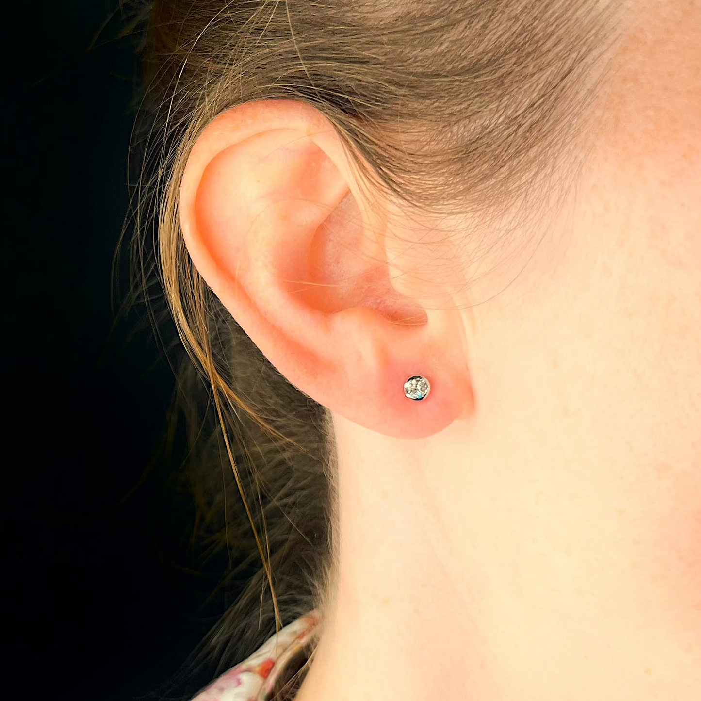 Solitärohrstecker mit Diamant gefasst in Weißgold Zargenfassung getragen am Ohr