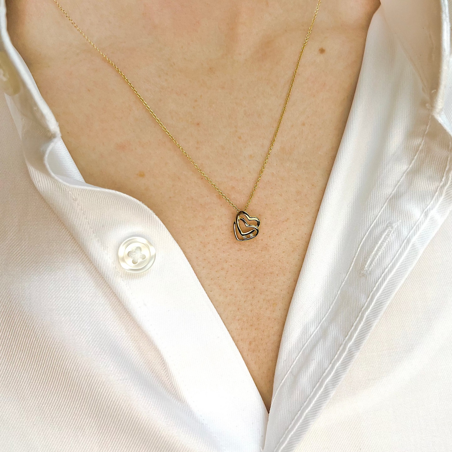 Anhänger aus Gelbgold mit zwei Herzen und zwei Diamanten an Halskette getragen