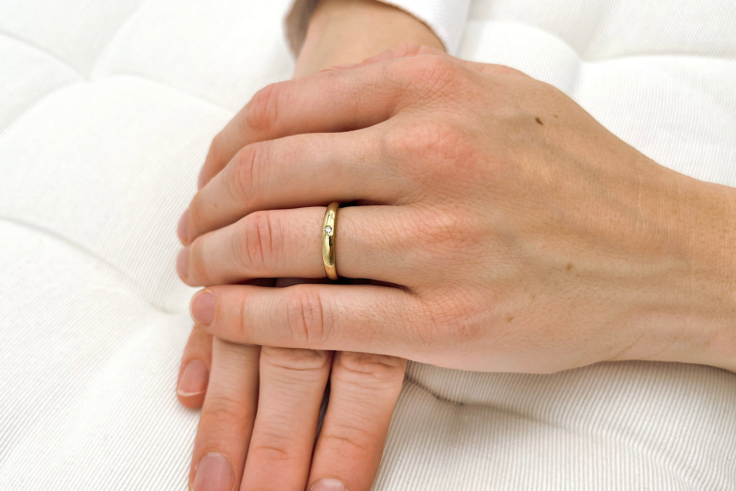 Schlichter Gelbgold Verlobungsring mit Solitärdiamant getragen an einer Frauenhand