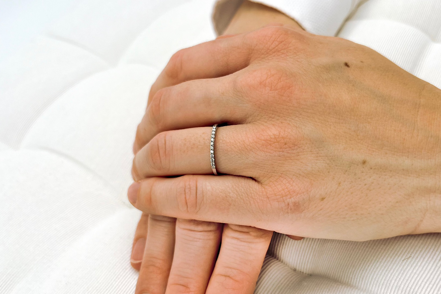 Vorsteckring aus Weißgold gefertigt mit 0,1ct als Halb-Memory-Ring an Frauenhand
